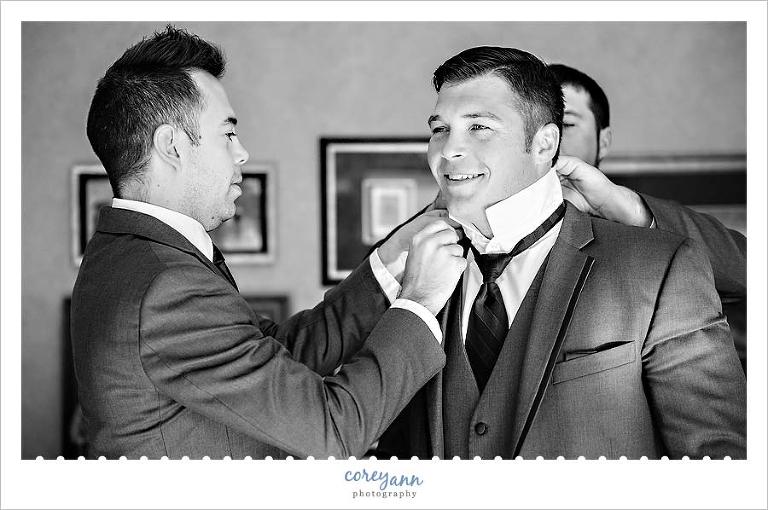 grooms brothers helping him get ready for wedding