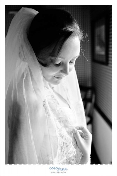 bride sitting by window with veil