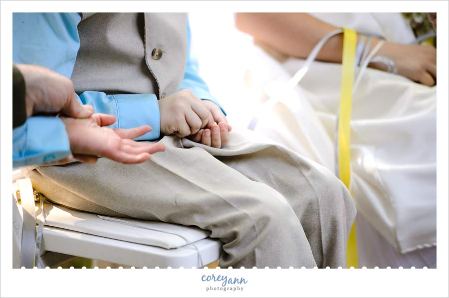 brides son holding rings during a ring warming ritual during ceremony