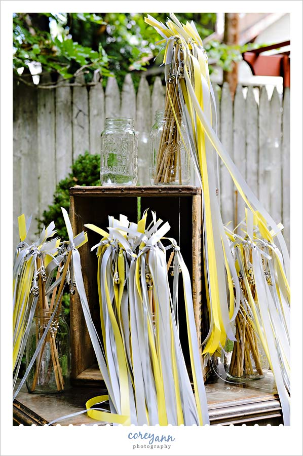 mason jars holding yellow and grey wands for waving after the wedding