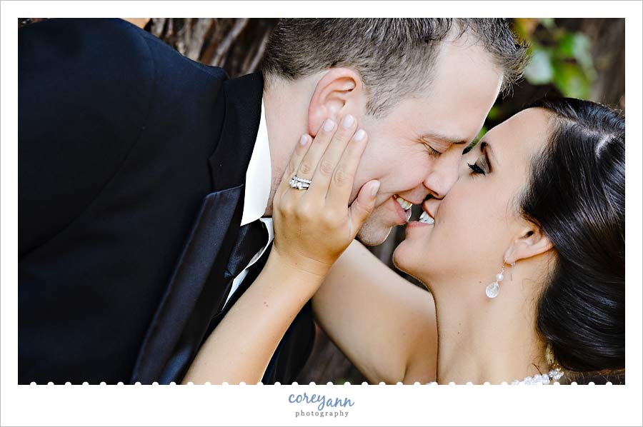bride and groom kissing on bridge near shooters in the flats