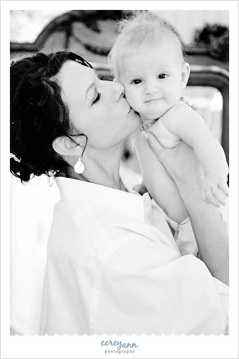 bride kissing baby while getting ready