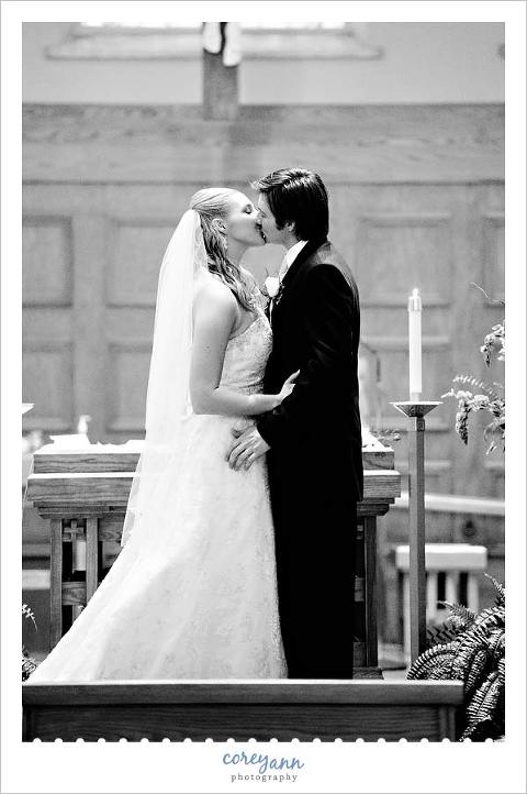 bride and groom first kiss during catholic wedding