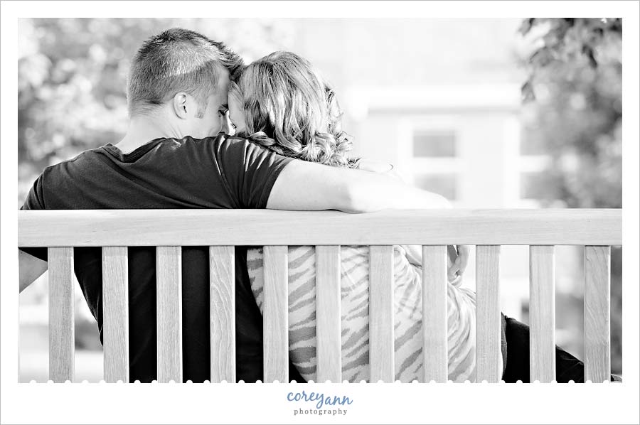 couple cuddling on bench at malone college