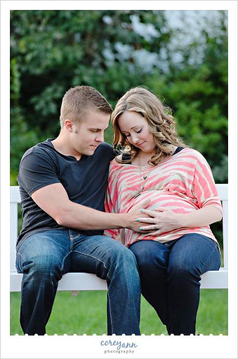 Maternity portrait of both parents on a bench
