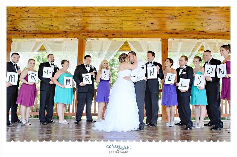 multi colored bridal party holding letters of married name