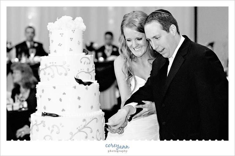 groom making a face during cake cutting