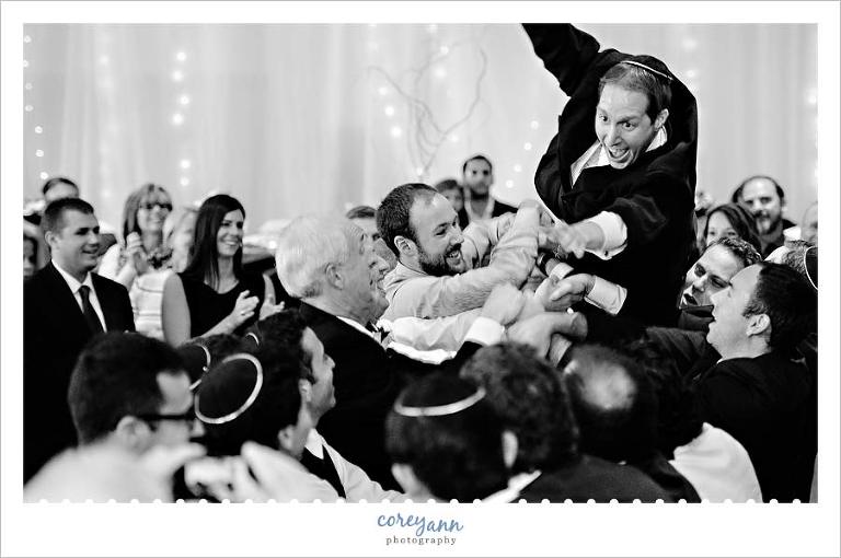 Groom being tossed into the air during the hora