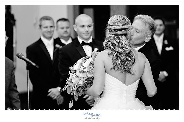 father of the bride kissing the bride when giving her away during wedding ceremony