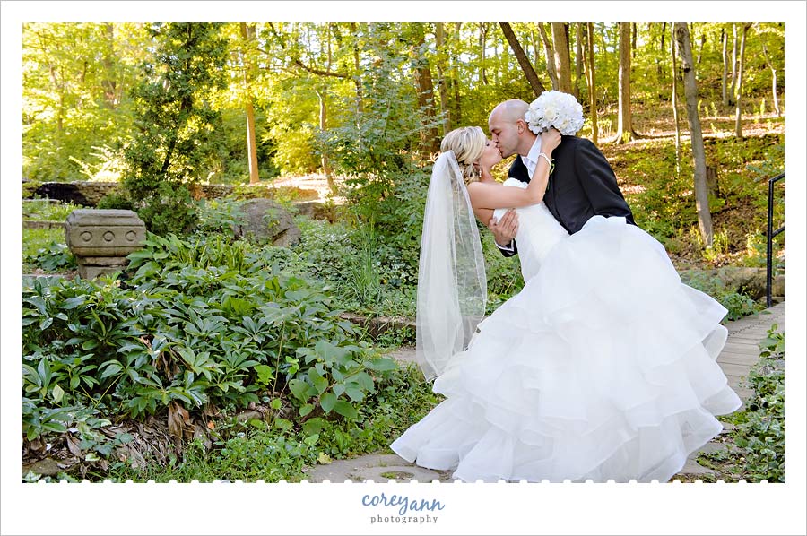groom dipping bride in a forest