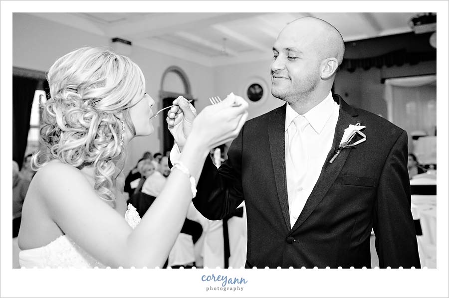bride and groom feeding each other cake with forks