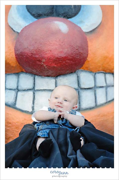 baby in bumbo seat in front of a pumpkin