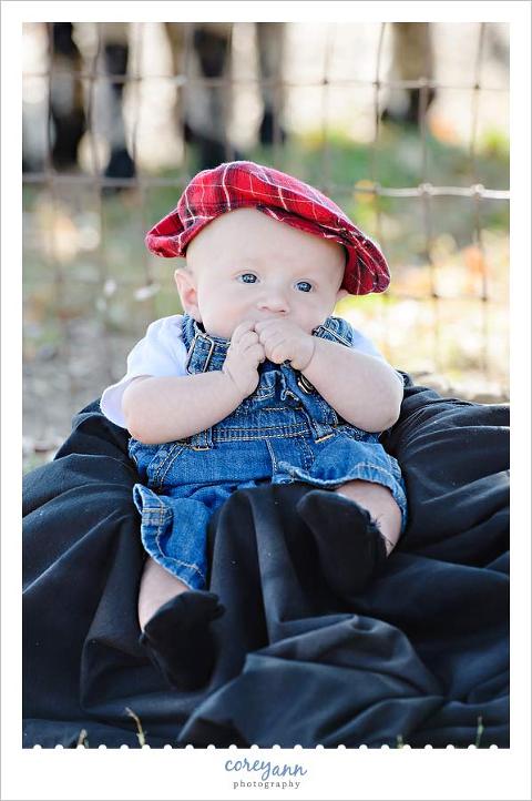 baby with red plaid hat and overalls