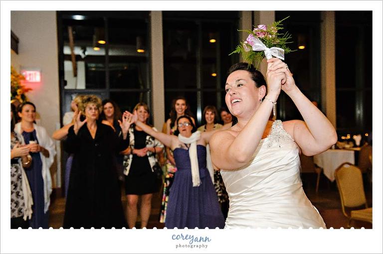 bride tossing the bouquet at wedding reception