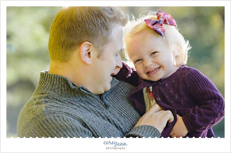 father and daughter giggling together during family portrait session
