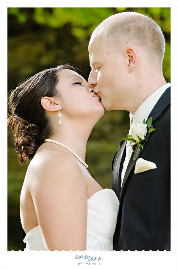 bride and groom kissing outside