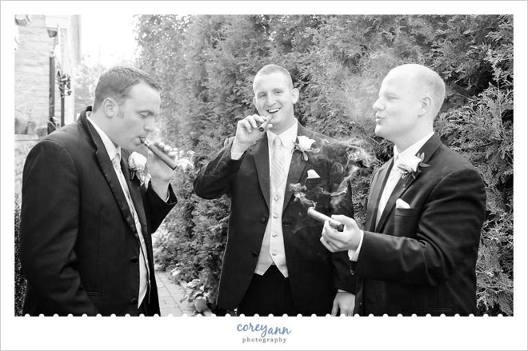 groom and groomsman smoking cigars