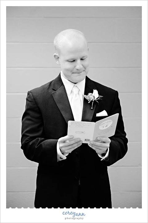 groom reading a card from the bride before wedding ceremony