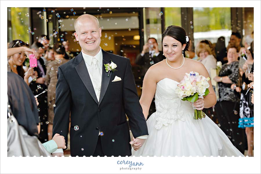 bride and groom exiting from wedding ceremony with bubbles