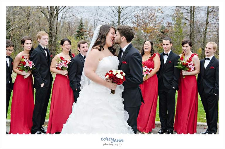 bride licking groom's nose in bridal party picture