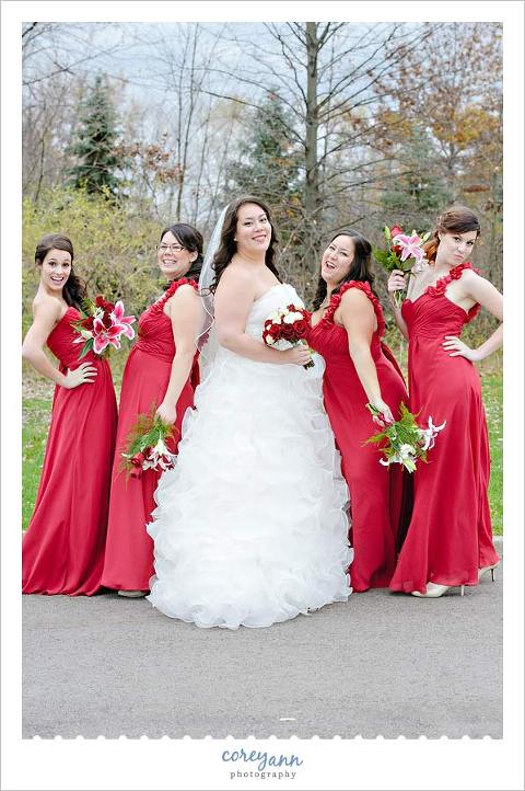 bride and bridesmaids in long red dresses with red bouquets