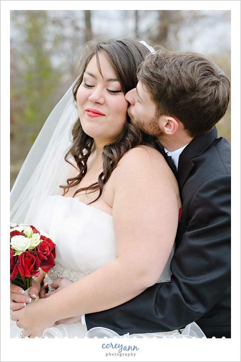 groom kissing bride on cheek