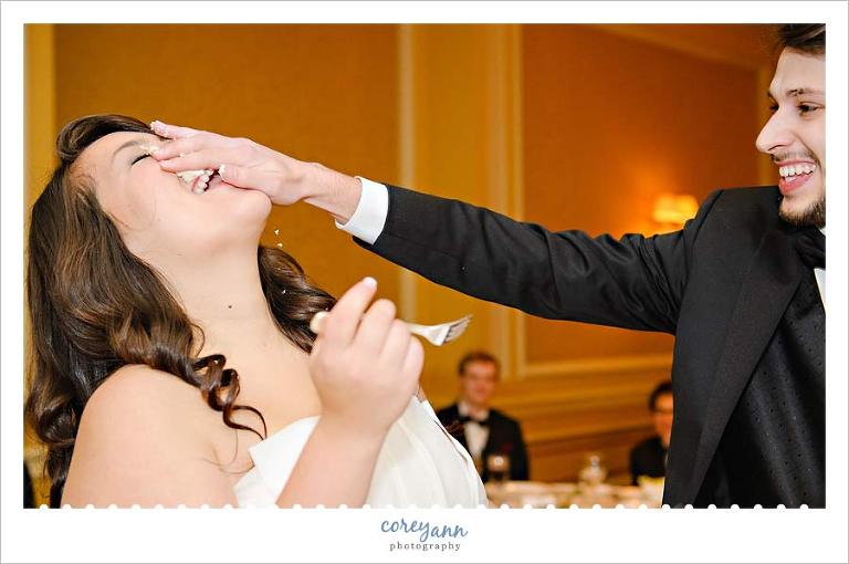 groom smashing cake in bride's face after cake cutting