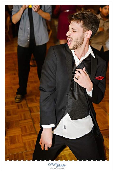 groom playing air guitar during wedding reception at The Ritz Carlton in Cleveland Ohio