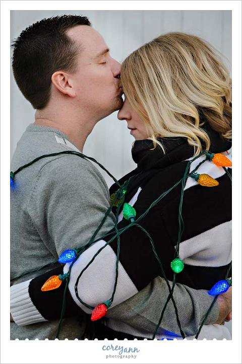 engagement portrait with christmas lights outside in november