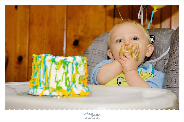 one year old tasting a cake at his monster themed birthday party