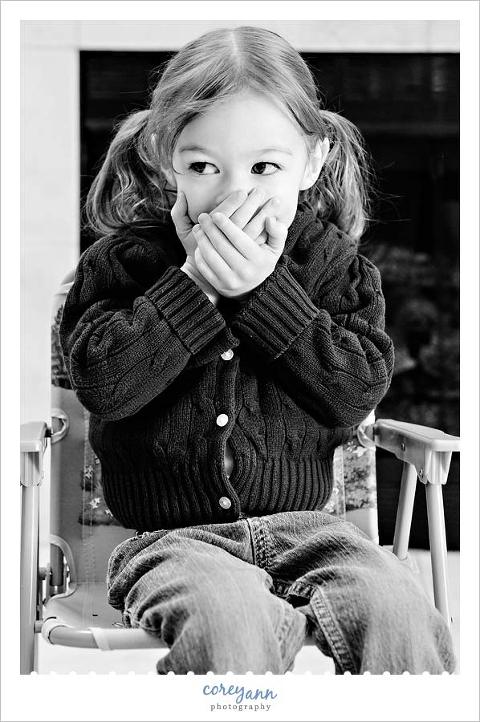 little girl covering her mouth