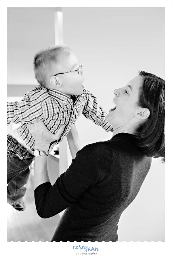mom and son laughing while she lifts him into the air