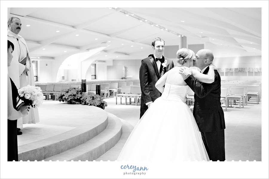 father of the bride handing off bride to groom during catholic ceremony
