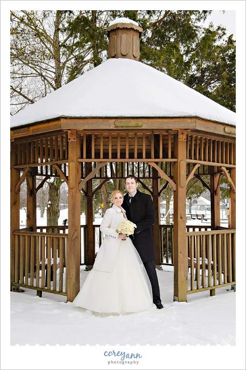bride and groom outdoors in a gazebo covered with snow