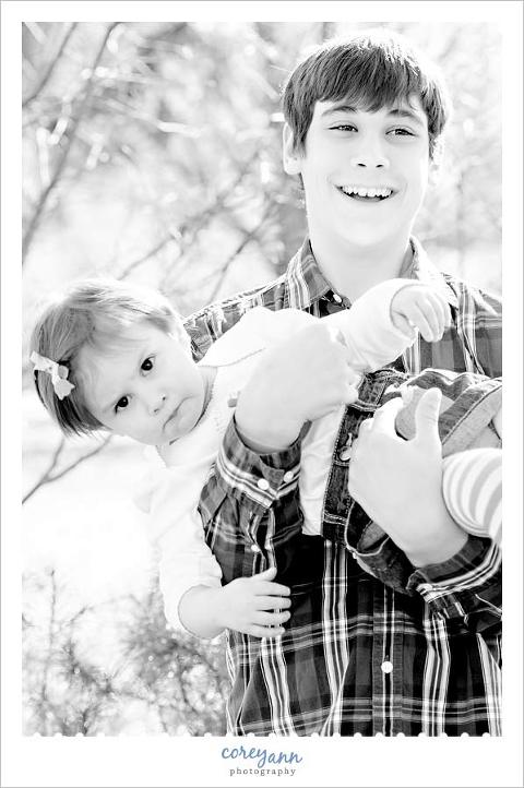 brother holding upset 2 year old sister