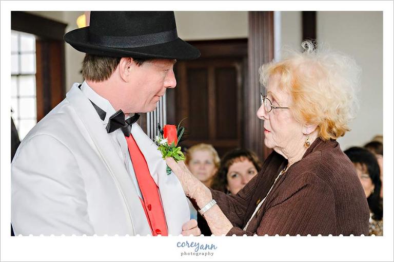 groom mother pinning on boutonniere
