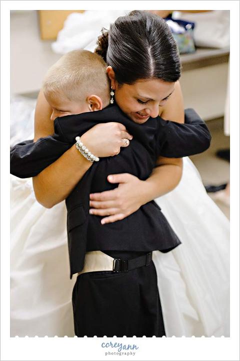 brides nephew giving her a hug before wedding ceremony