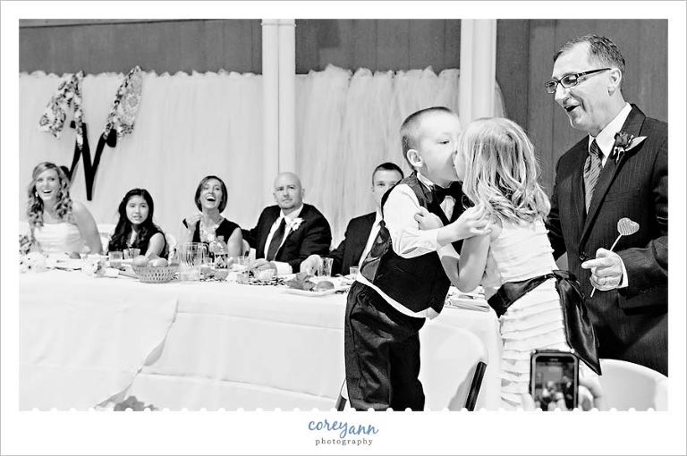 ring bearer and flower girl kissing at wedding reception in elyria