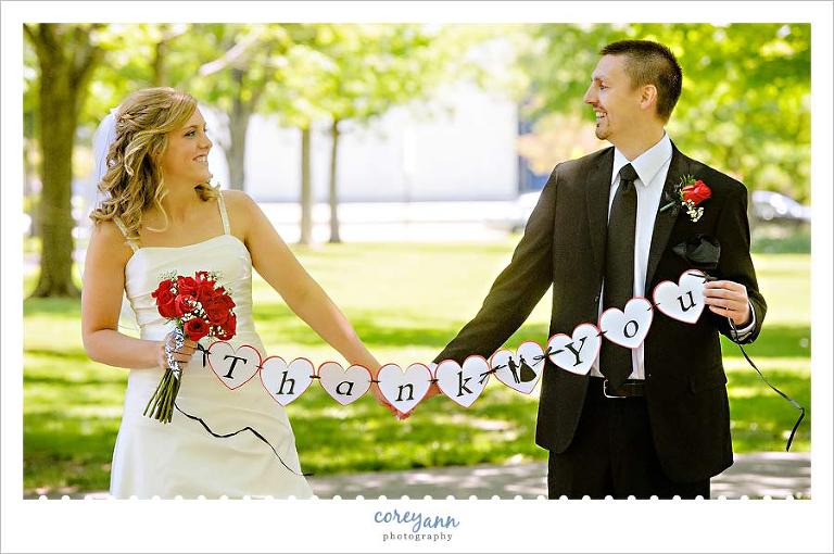 bride and groom holding thank you sign