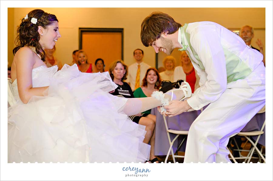 groom removing garter during reception at holden arboretum