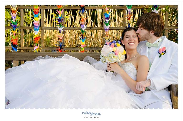 bride and groom posing with paper cranes they folded