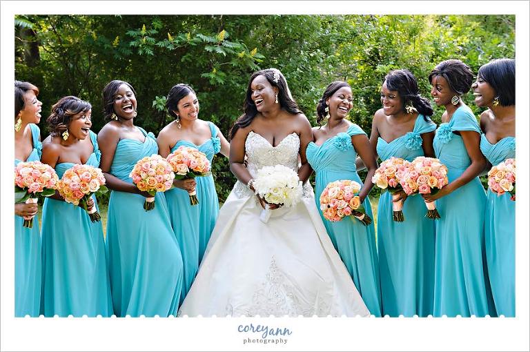 bridesmaids in long teal dresses with pink bouquets