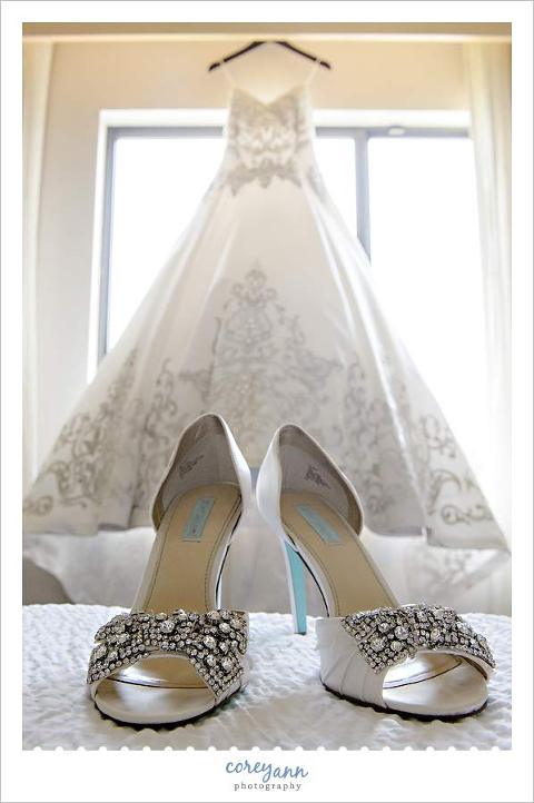 white wedding shoes with blue heel against wedding dress in window