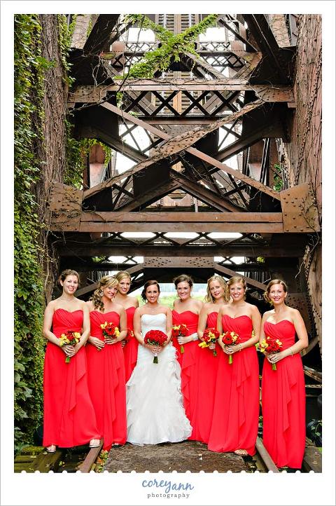 bridesmaids in long red dresses with red and yellow bouquets