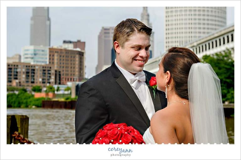 bride and groom posed in front of the cleveland skyline