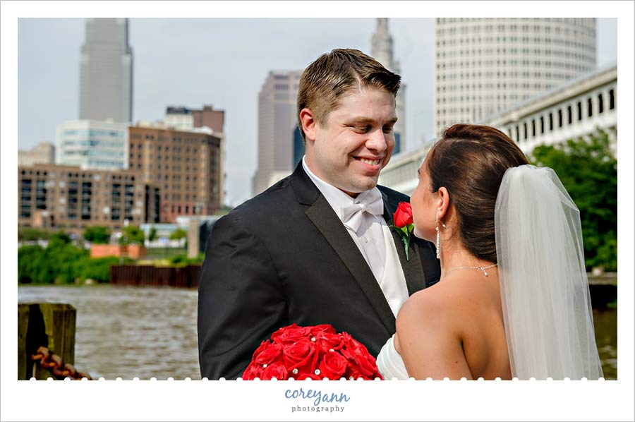 bride and groom posed in front of the cleveland skyline