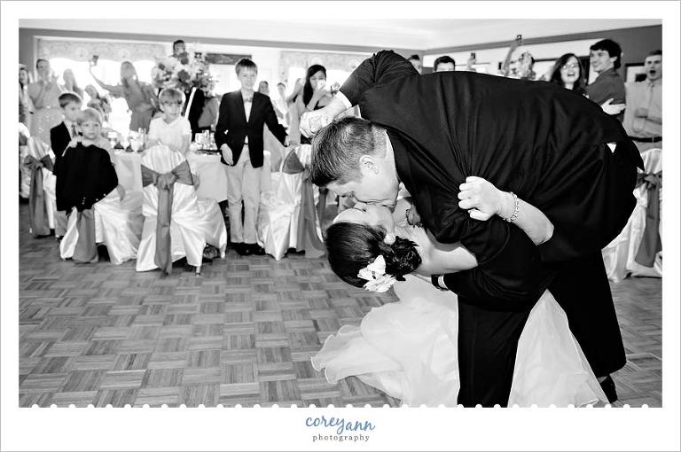 groom dipping and kissing the bride after grand wedding reception entrance