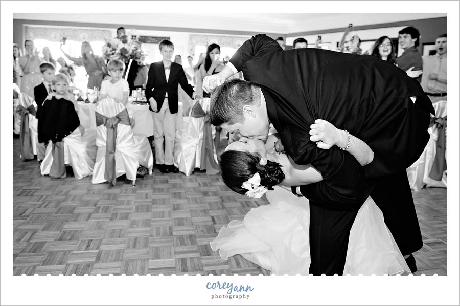 groom dipping and kissing the bride after grand wedding reception entrance
