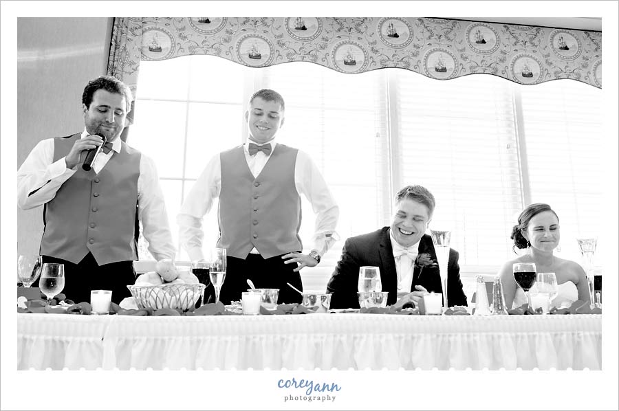 two best men giving wedding toast to bride and groom at reception