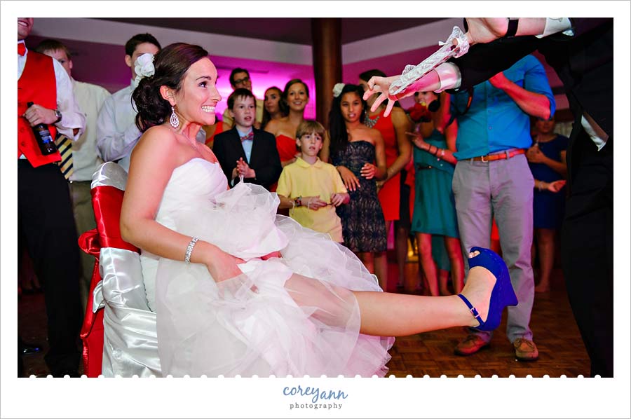 groom removing garter from bride's leg